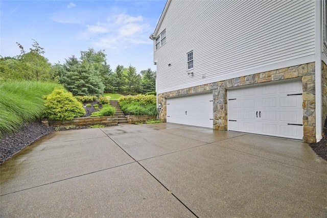 140 Golfview Dr, Adams Twp, PA 15044 - view of side of property featuring stone siding, driveway, and an attached garage