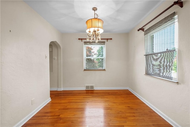 129 Temona Dr, Pleasant Hills, PA 15236 - empty room with arched walkways, a chandelier, and hardwood / wood-style floors