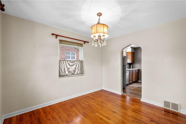 129 Temona Dr, Pleasant Hills, PA 15236 - unfurnished room featuring arched walkways, hardwood / wood-style flooring, and a chandelier