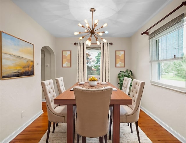 129 Temona Dr, Pleasant Hills, PA 15236 - dining room with arched walkways, healthy amount of natural light, a chandelier, and wood finished floors