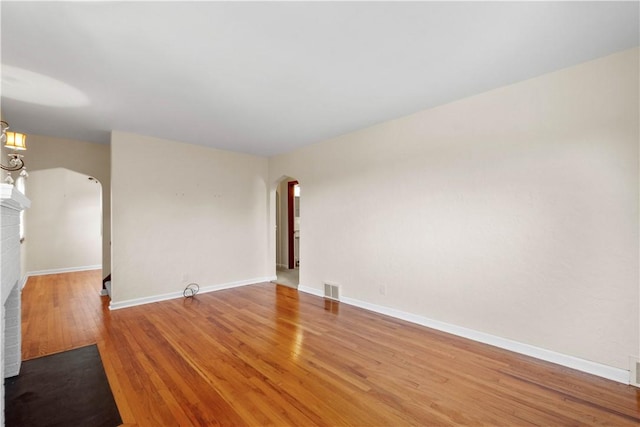 129 Temona Dr, Pleasant Hills, PA 15236 - spare room with arched walkways, light wood-style floors, and a fireplace