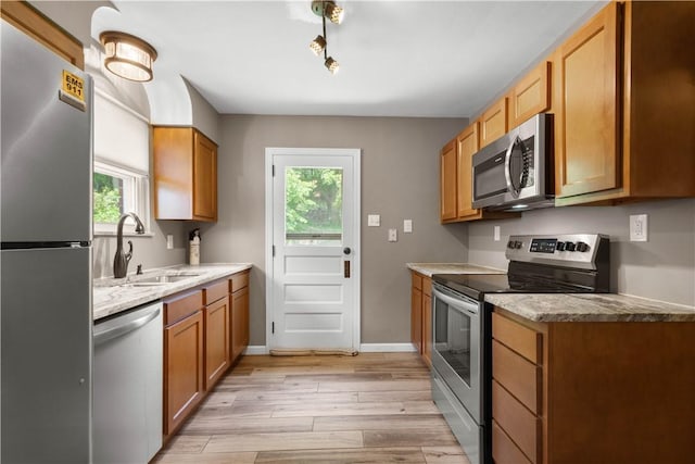 129 Temona Dr, Pleasant Hills, PA 15236 - kitchen with appliances with stainless steel finishes, light wood-type flooring, and brown cabinetry