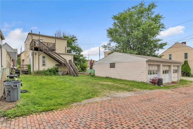 957-959 5th Ave, East Mckeesport, PA 15035 - view of side of home with decorative driveway, a lawn, stairway, an attached garage, and an outbuilding