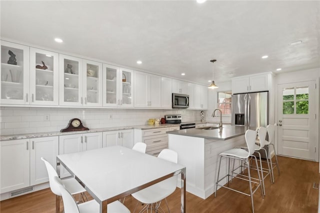 221 Miller Ave, Duquesne, PA 15110 - kitchen featuring appliances with stainless steel finishes, a center island with sink, backsplash, white cabinetry, and recessed lighting