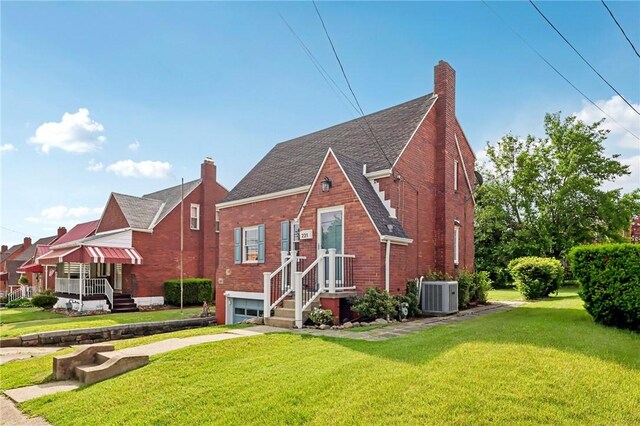 221 Miller Ave, Duquesne, PA 15110 - english style home featuring brick siding, roof with shingles, a front yard, a garage, and concrete driveway