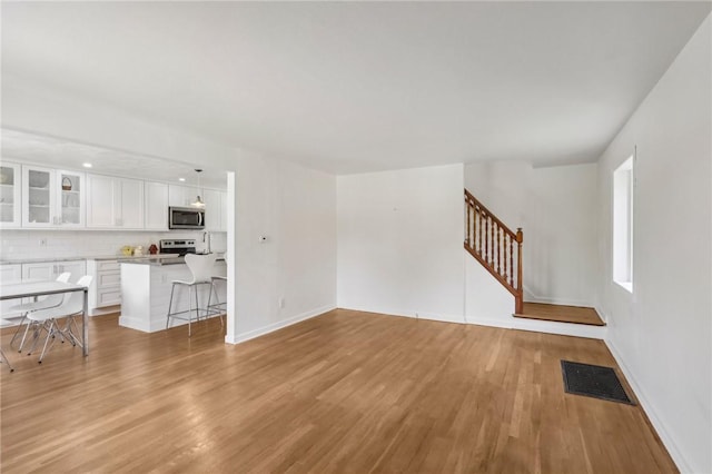 221 Miller Ave, Duquesne, PA 15110 - unfurnished living room featuring light wood-type flooring and stairway