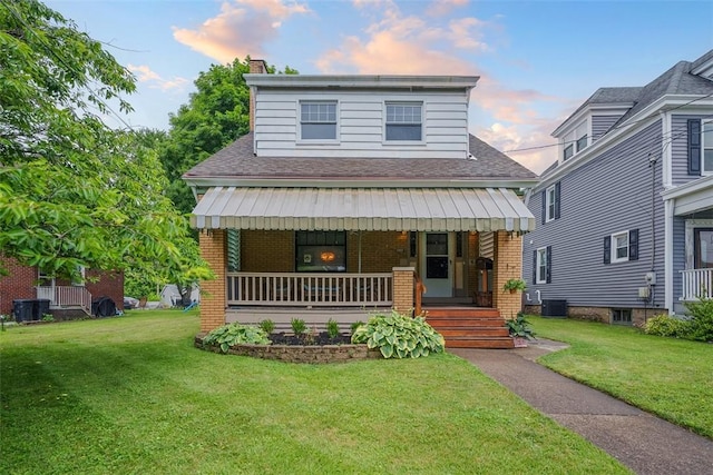 3123 Willett Rd, Brentwood, PA 15227 - view of front facade featuring covered porch, brick siding, a yard, and a shingled roof