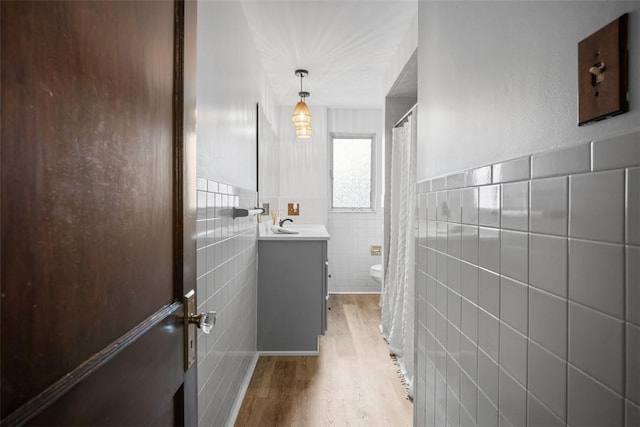 3123 Willett Rd, Brentwood, PA 15227 - bathroom featuring tile walls, wood finished floors, vanity, a shower with curtain, and wainscoting