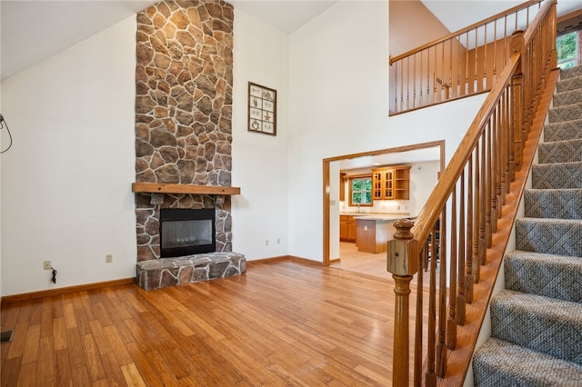 29 Cherry Tree Ln, Mercer Boro Mer, PA 16137 - living room with light wood-type flooring, high vaulted ceiling, a stone fireplace, and stairway