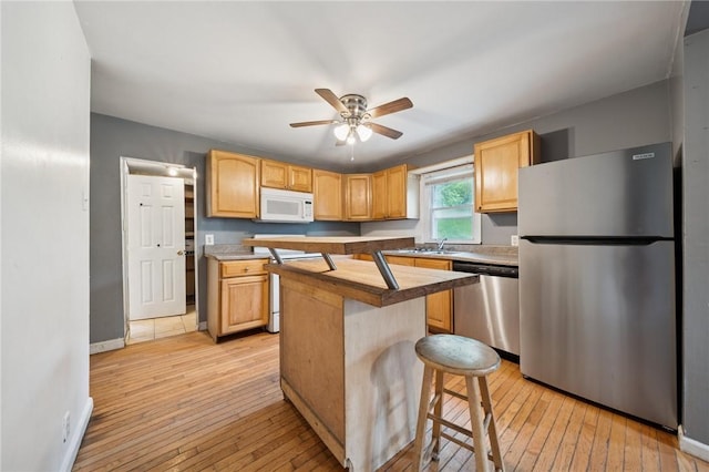 320 Cline St, E Pittsburgh, PA 15112 - kitchen featuring stainless steel appliances, ceiling fan, light wood finished floors, and light brown cabinetry