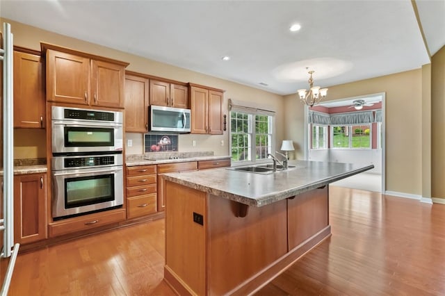 121 Anglers Way, Peters Twp, PA 15317 - kitchen featuring appliances with stainless steel finishes, light wood-style flooring, a chandelier, brown cabinetry, and light countertops