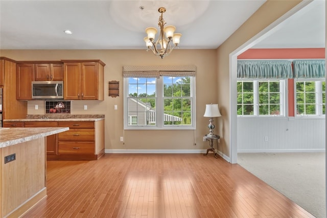 121 Anglers Way, Peters Twp, PA 15317 - kitchen featuring stainless steel microwave, light countertops, brown cabinetry, a chandelier, and plenty of natural light