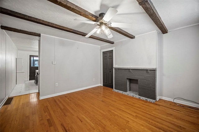 4829 Hatfield St, Lawrenceville, PA 15201 - unfurnished living room with beam ceiling, wood finished floors, ceiling fan, and a fireplace