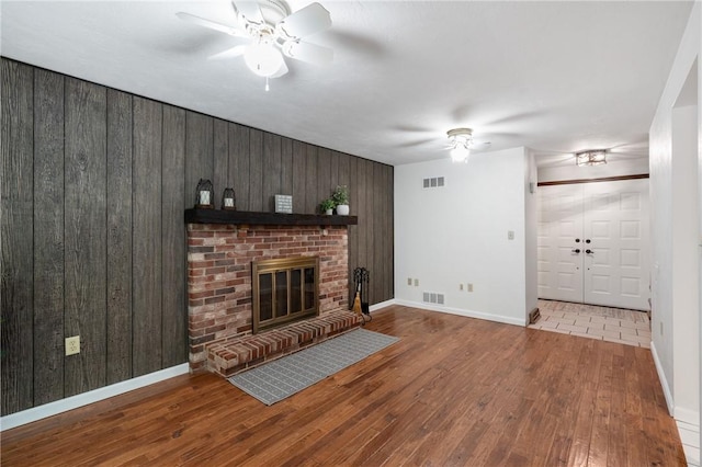 255 Kittanning Pike, Ohara, PA 15215 - unfurnished living room featuring ceiling fan, wood-type flooring, wooden walls, and a brick fireplace