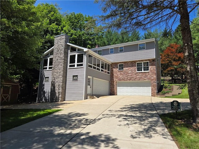 255 Kittanning Pike, Ohara, PA 15215 - view of front of house with concrete driveway, a chimney, an attached garage, brick siding, and view of scattered trees