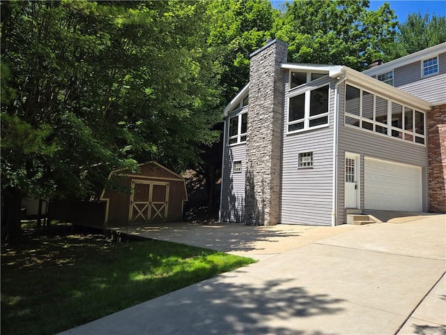 255 Kittanning Pike, Ohara, PA 15215 - view of property exterior with a shed, a chimney, concrete driveway, and an attached garage