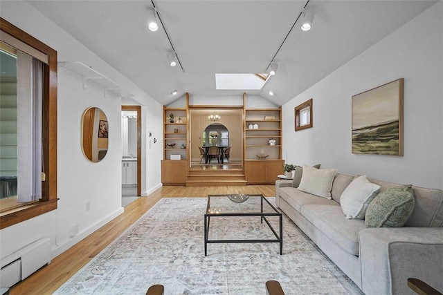 4035 Ludwick St, Squirrel Hill, PA 15217 - living area featuring baseboard heating, a skylight, light wood-style flooring, lofted ceiling, and built in features