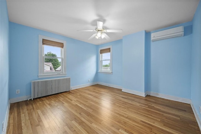 4035 Ludwick St, Squirrel Hill, PA 15217 - spare room with radiator heating unit, a wall mounted AC, healthy amount of natural light, and hardwood / wood-style flooring
