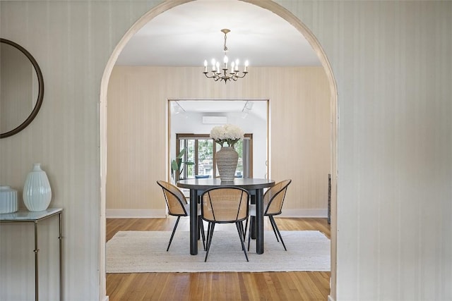 4035 Ludwick St, Squirrel Hill, PA 15217 - dining room featuring arched walkways, a chandelier, light wood finished floors, and wallpapered walls