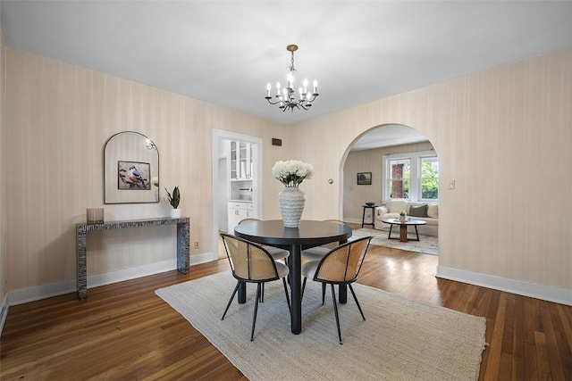 4035 Ludwick St, Squirrel Hill, PA 15217 - dining room featuring arched walkways, a chandelier, wood finished floors, and wallpapered walls