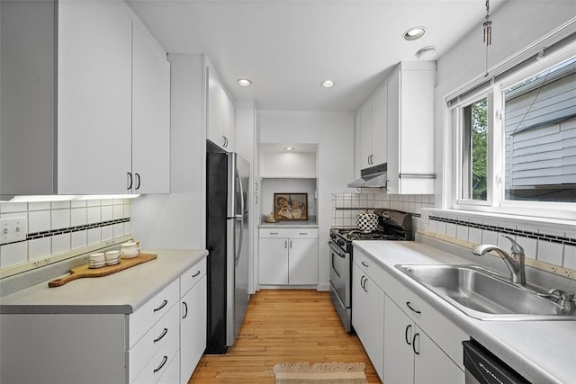 4035 Ludwick St, Squirrel Hill, PA 15217 - kitchen featuring appliances with stainless steel finishes, under cabinet range hood, decorative backsplash, white cabinets, and light countertops