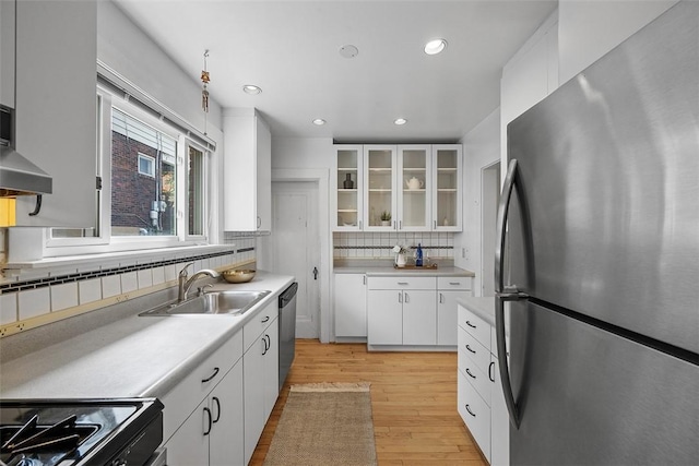 4035 Ludwick St, Squirrel Hill, PA 15217 - kitchen with stainless steel appliances, light wood finished floors, decorative backsplash, light countertops, and white cabinetry