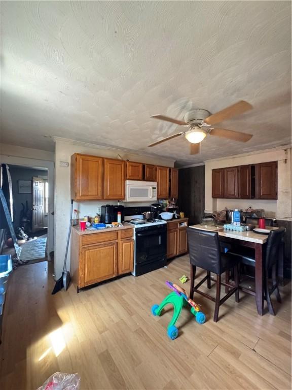 200 Jarvis St, Aliquippa, PA 15001 - kitchen featuring white microwave, electric range oven, light wood-style floors, and ceiling fan