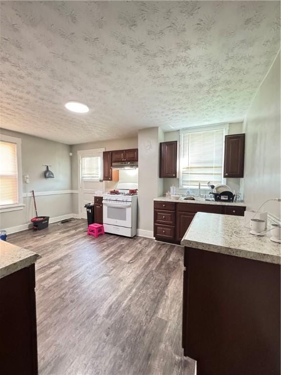 200 Jarvis St, Aliquippa, PA 15001 - kitchen featuring gas range gas stove, dark wood-type flooring, under cabinet range hood, dark brown cabinets, and a textured ceiling