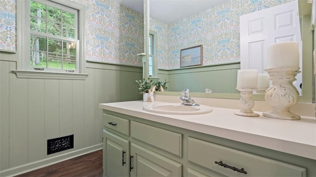 609 Twin Pine Rd, Fox Chapel, PA 15215 - bathroom featuring wallpapered walls, vanity, wood finished floors, wainscoting, and a decorative wall