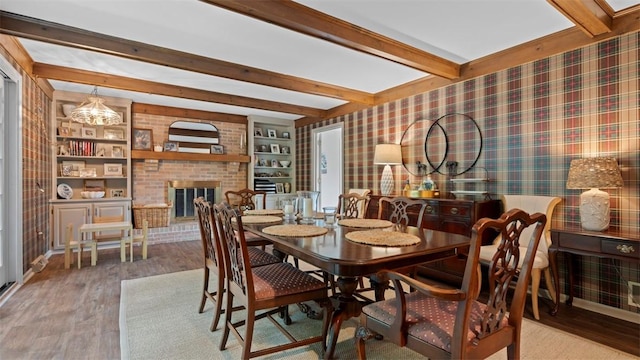 609 Twin Pine Rd, Fox Chapel, PA 15215 - dining room with wallpapered walls, beam ceiling, wood finished floors, a brick fireplace, and a chandelier