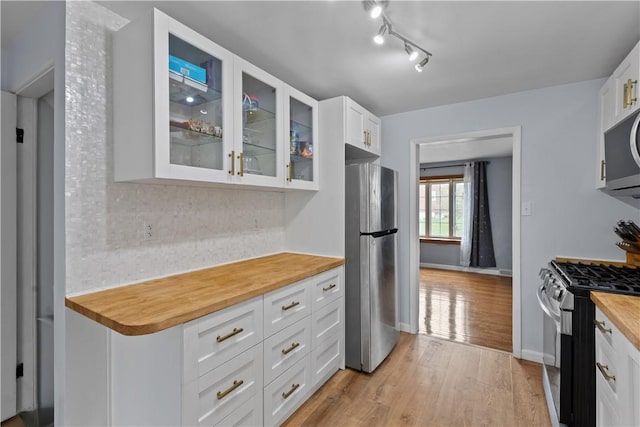 1028 Roseanne Ave, Banksville/Westwood, PA 15216 - kitchen featuring appliances with stainless steel finishes, light wood-type flooring, glass insert cabinets, white cabinets, and tasteful backsplash