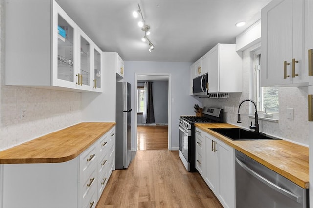 1028 Roseanne Ave, Banksville/Westwood, PA 15216 - kitchen featuring stainless steel appliances, wood counters, glass insert cabinets, backsplash, and light wood-style flooring