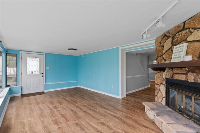 1028 Roseanne Ave, Banksville/Westwood, PA 15216 - unfurnished living room with wood finished floors, a stone fireplace, and rail lighting