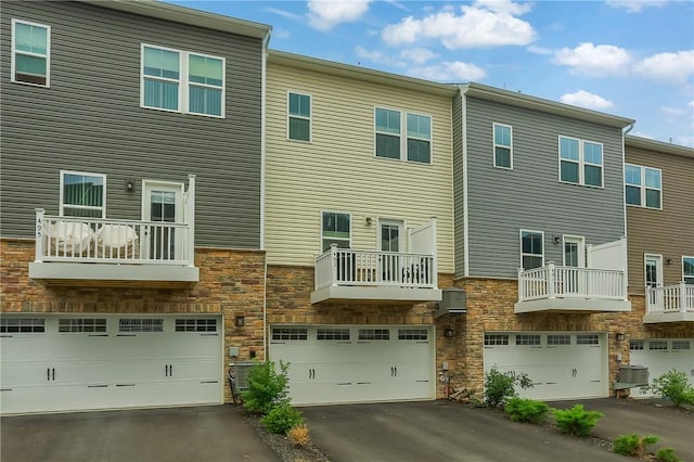 493 Nolan Cir, Cranberry Twp, PA 16066 - rear view of house with stone siding, an attached garage, and driveway