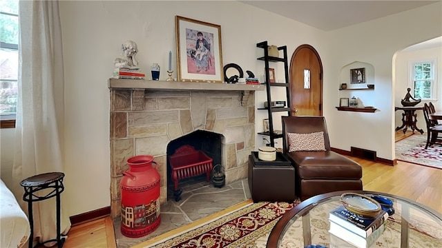 217 Monroe Dr, Ross Twp, PA 15229 - living room featuring wood finished floors, arched walkways, and a fireplace with flush hearth