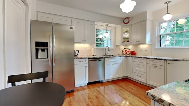 217 Monroe Dr, Ross Twp, PA 15229 - kitchen featuring stainless steel appliances, light wood finished floors, backsplash, and light stone countertops