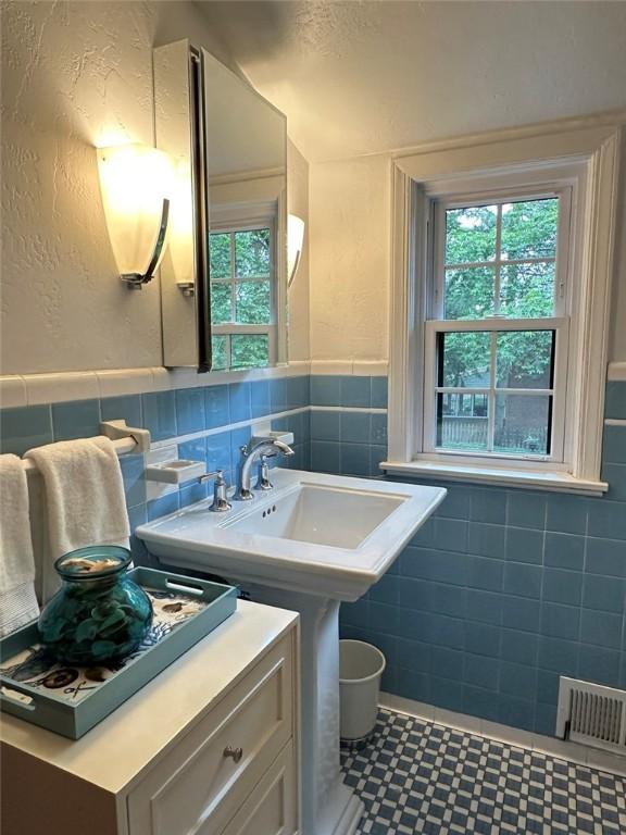 217 Monroe Dr, Ross Twp, PA 15229 - bathroom with tile walls, healthy amount of natural light, a wainscoted wall, tile patterned floors, and a textured wall