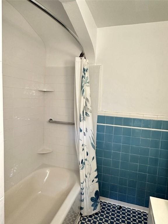 217 Monroe Dr, Ross Twp, PA 15229 - bathroom featuring tile walls, shower / tub combo, and wainscoting