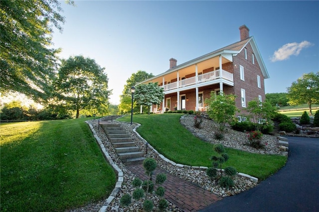 255 Camp Run Rd, Lancaster Twp, PA 16037 - exterior space featuring a chimney, a balcony, a front yard, brick siding, and stairway