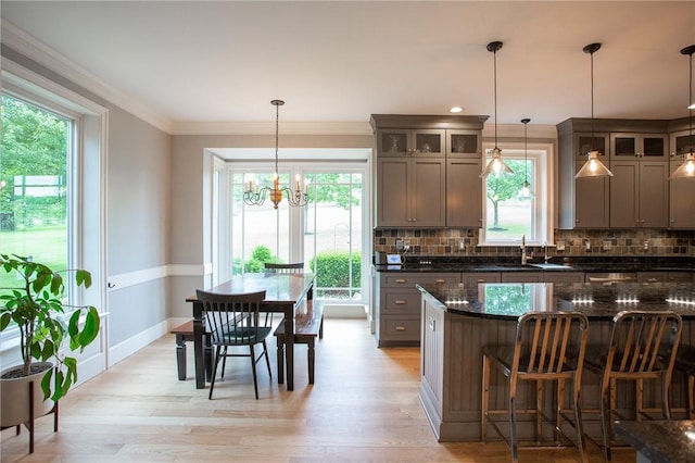 255 Camp Run Rd, Lancaster Twp, PA 16037 - kitchen featuring backsplash, light wood-type flooring, a kitchen breakfast bar, a chandelier, and glass insert cabinets