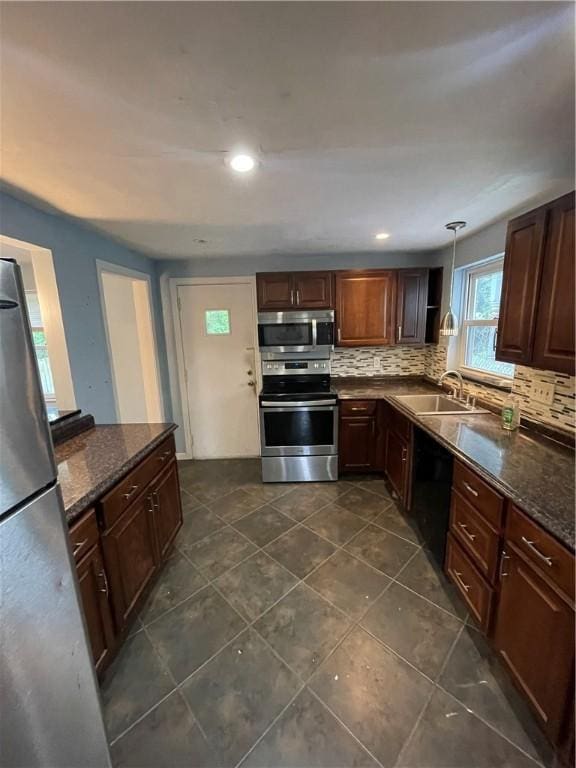 1114 Ingham St, Marshall Shadeland, PA 15212 - kitchen featuring appliances with stainless steel finishes, backsplash, hanging light fixtures, dark tile patterned flooring, and dark stone counters