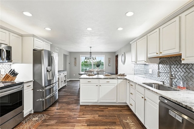 2310 Shamrock Ln, Canonsburg, PA 15317 - kitchen with appliances with stainless steel finishes, a peninsula, recessed lighting, decorative backsplash, and dark wood-style floors