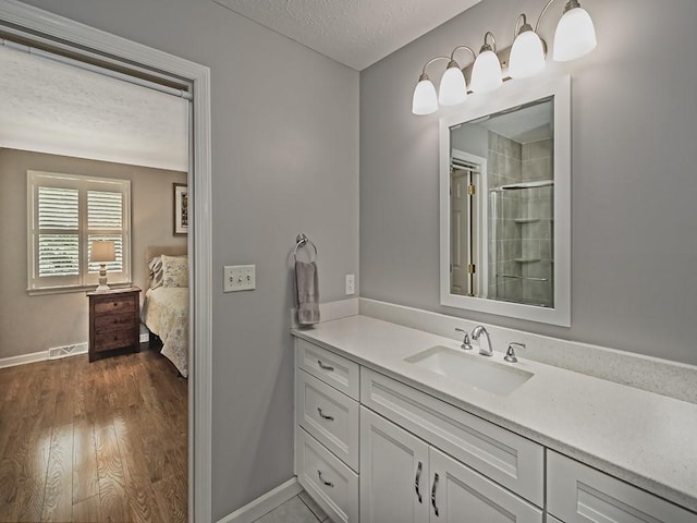 406 Country View Dr, Lower Burrell, PA 15068 - ensuite bathroom featuring a textured ceiling, vanity, a shower with shower door, and wood finished floors