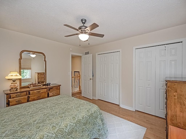 406 Country View Dr, Lower Burrell, PA 15068 - bedroom with wood finished floors, multiple closets, a textured ceiling, and a ceiling fan