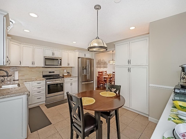 406 Country View Dr, Lower Burrell, PA 15068 - kitchen featuring appliances with stainless steel finishes, light tile patterned floors, backsplash, pendant lighting, and recessed lighting