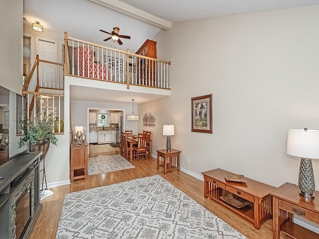 406 Country View Dr, Lower Burrell, PA 15068 - living room featuring ceiling fan, beam ceiling, wood finished floors, stairway, and high vaulted ceiling