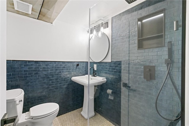 213 Thistle Dr, West Mifflin, PA 15122 - bathroom featuring tile patterned flooring, tile walls, wainscoting, and a tile shower