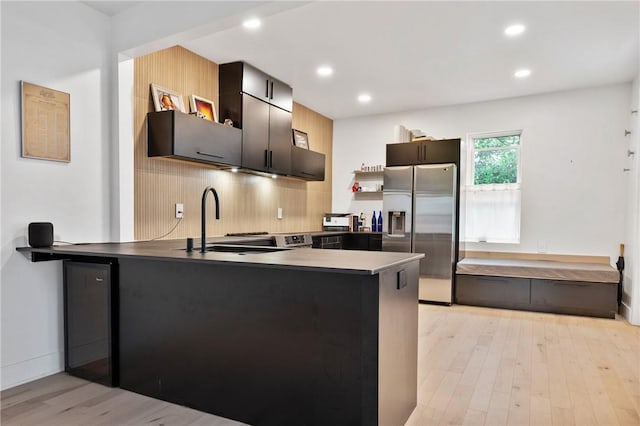 2013 Straubs Ln, Troy Hill, PA 15212 - kitchen featuring stainless steel fridge with ice dispenser, a peninsula, light wood-style floors, recessed lighting, and backsplash
