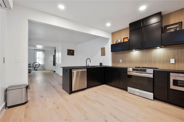 2013 Straubs Ln, Troy Hill, PA 15212 - kitchen featuring appliances with stainless steel finishes, a peninsula, a wall mounted air conditioner, dark cabinetry, and light wood-type flooring