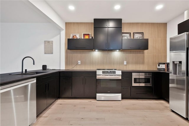 2013 Straubs Ln, Troy Hill, PA 15212 - kitchen with appliances with stainless steel finishes, dark countertops, light wood-type flooring, recessed lighting, and decorative backsplash